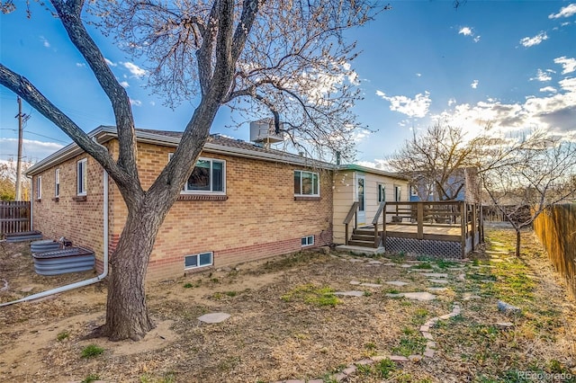 6095 W 47th Ave, Wheat Ridge, CO 80033 - rear view of property featuring brick siding, a fenced backyard, and a deck