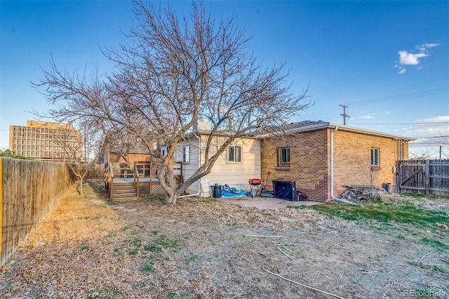 6095 W 47th Ave, Wheat Ridge, CO 80033 - back of property with a deck, a fenced backyard, and brick siding