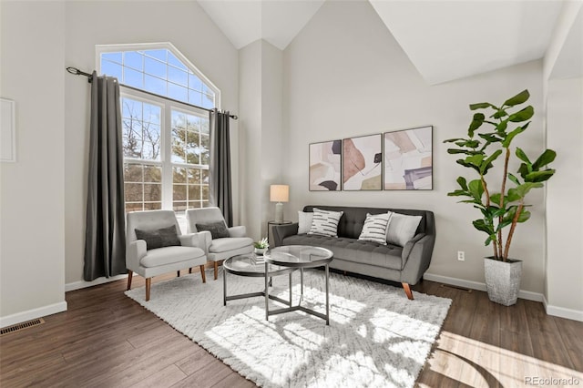 living room featuring high vaulted ceiling and dark hardwood / wood-style floors