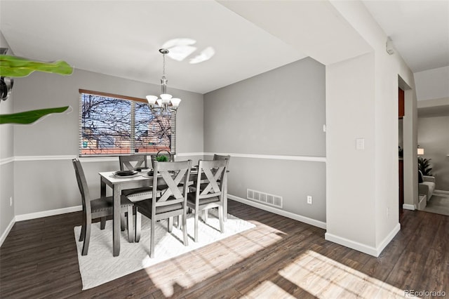 dining room featuring dark wood-type flooring and a notable chandelier