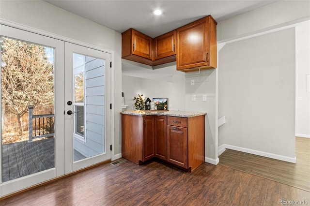 bar featuring french doors, dark hardwood / wood-style flooring, and light stone countertops