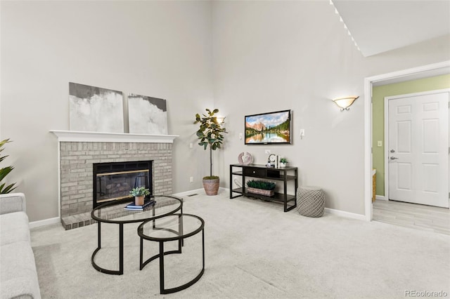 living room with a towering ceiling, light colored carpet, and a fireplace