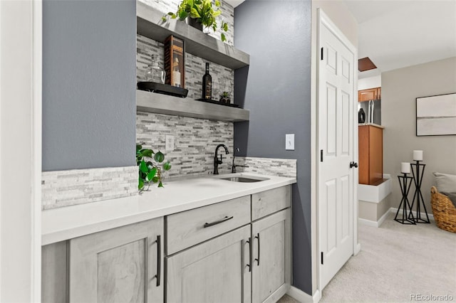 bar featuring light carpet, sink, and decorative backsplash