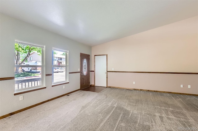 carpeted empty room featuring baseboards