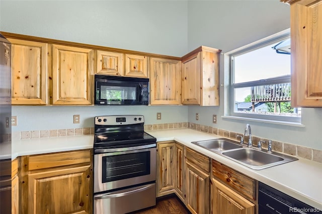 kitchen featuring black microwave, stainless steel range with electric cooktop, a sink, dishwashing machine, and light countertops