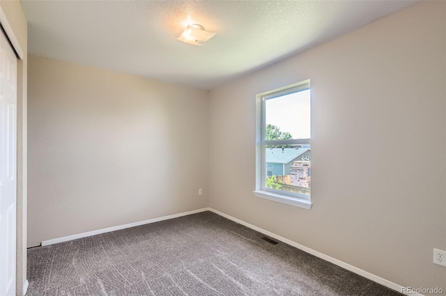 unfurnished room featuring carpet and baseboards
