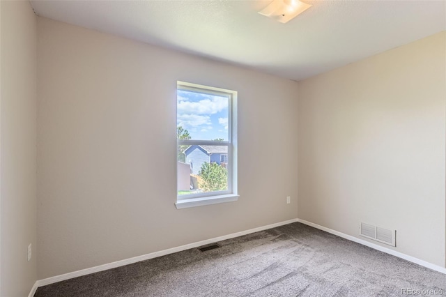 unfurnished room featuring carpet and baseboards