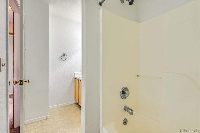 bathroom featuring tub / shower combination, vanity, and baseboards