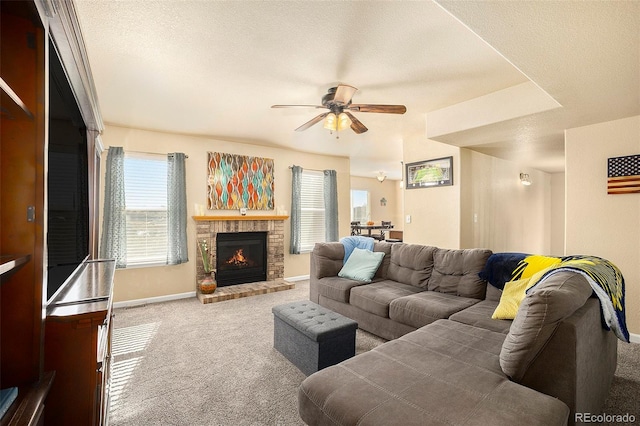 living area with ceiling fan, a textured ceiling, carpet, and a fireplace