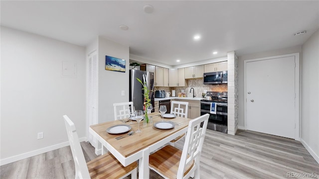 dining space featuring recessed lighting, light wood-style flooring, and baseboards