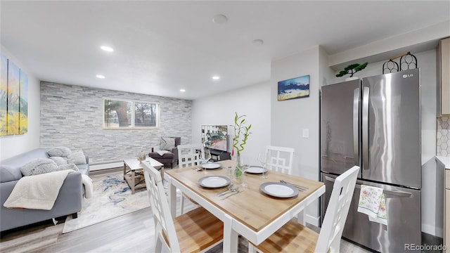 dining space featuring baseboard heating, light wood-style flooring, and recessed lighting