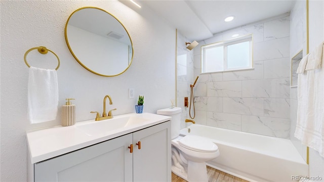 full bathroom with visible vents, toilet, wood finished floors, tub / shower combination, and vanity