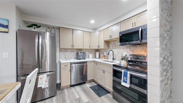 8826 E Florida Ave Unit G12, Denver, CO 80247 - kitchen with stainless steel appliances, a sink, light countertops, light wood-style floors, and backsplash