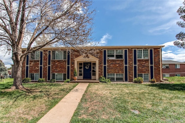 bi-level home with brick siding and a front lawn