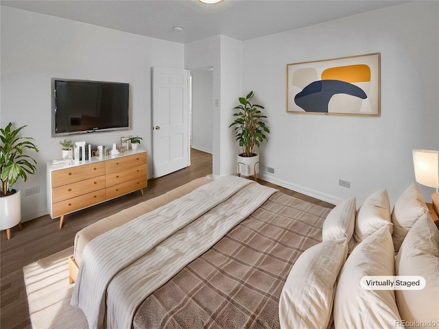 bedroom featuring baseboards and wood finished floors