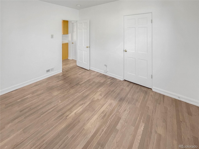 unfurnished bedroom with light wood finished floors, visible vents, and baseboards