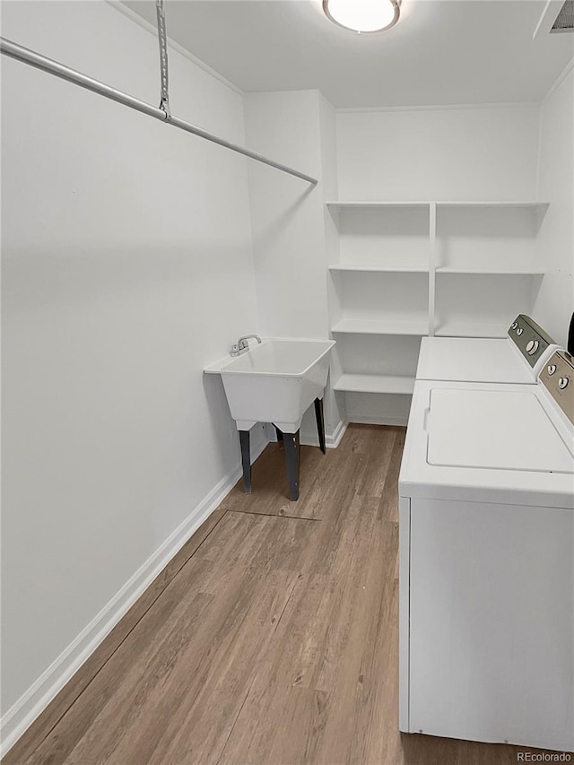 laundry room featuring baseboards, wood finished floors, visible vents, and washer and dryer