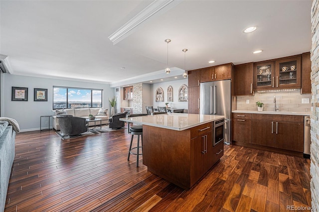 1551 Larimer St Unit 2602, Denver, CO 80202 - kitchen featuring a breakfast bar area, a sink, open floor plan, dark wood finished floors, and light countertops