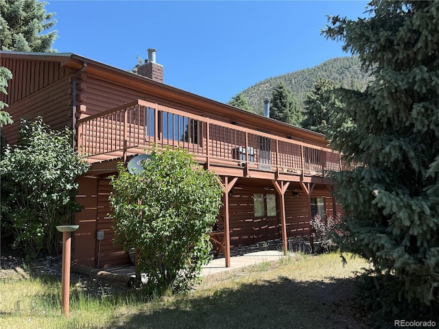 36 Woodchuck Dr, South Fork, CO 81154 - rear view of house with a deck with mountain view, a chimney, and log exterior