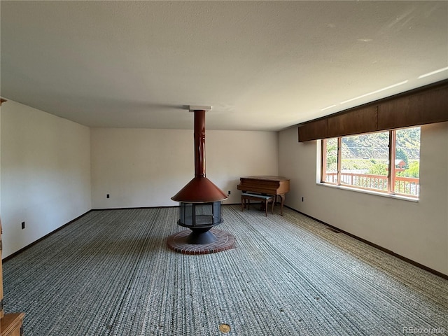 36 Woodchuck Dr, South Fork, CO 81154 - unfurnished room with a wood stove and carpet