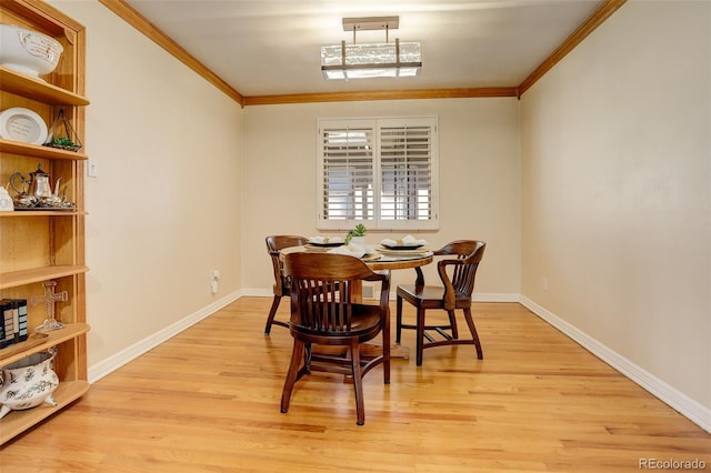 dining room with ornamental molding and light wood-type flooring