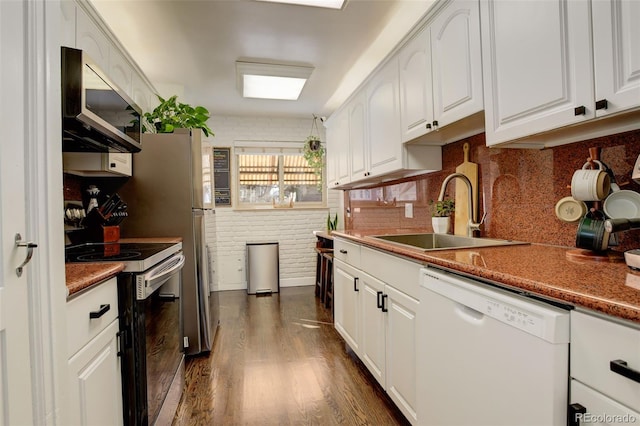 kitchen with dark wood-type flooring, sink, appliances with stainless steel finishes, brick wall, and white cabinets