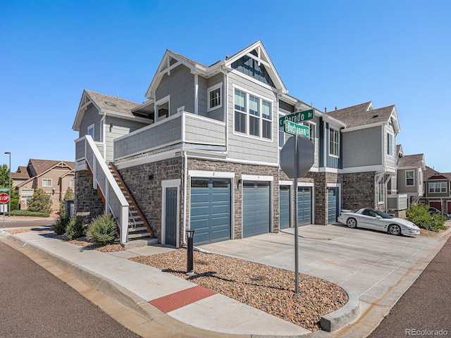 5755 S Buchanan Ct Unit E, Aurora, CO 80016 - townhome / multi-family property with stone siding, a garage, and driveway