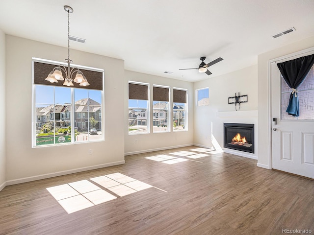 5755 S Buchanan Ct Unit E, Aurora, CO 80016 - unfurnished living room with wood finished floors, a glass covered fireplace, a chandelier, and ceiling fan
