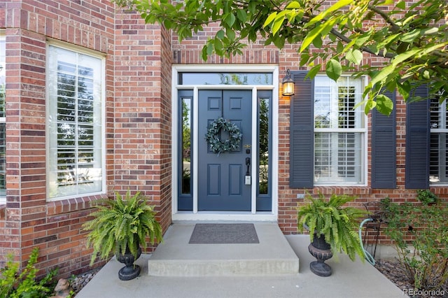 doorway to property featuring brick siding