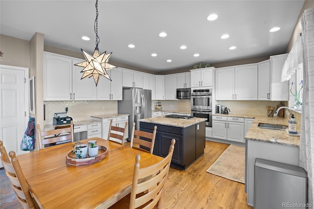 kitchen featuring a sink, appliances with stainless steel finishes, white cabinets, light wood-style floors, and recessed lighting