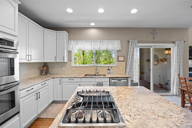 kitchen featuring a sink, appliances with stainless steel finishes, tasteful backsplash, white cabinetry, and recessed lighting