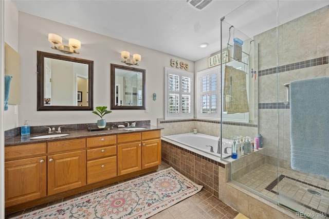 full bath featuring a stall shower, tile patterned floors, double vanity, and a garden tub