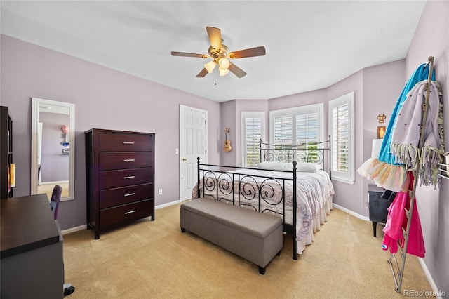 bedroom with light colored carpet, baseboards, and a ceiling fan