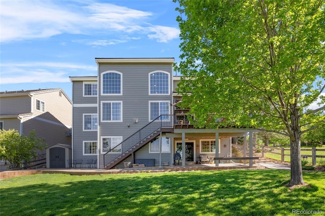 rear view of house featuring stairway, a shed, a deck, an outbuilding, and a patio area