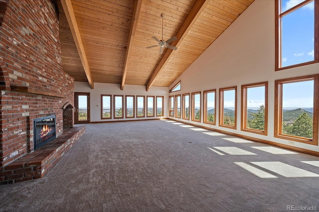 5197 Bear Mountain Dr, Evergreen, CO 80439 - unfurnished living room with wood ceiling, high vaulted ceiling, a brick fireplace, carpet floors, and beamed ceiling