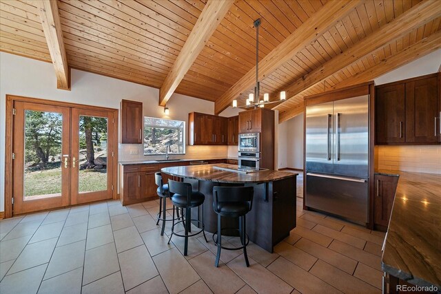 5197 Bear Mountain Dr, Evergreen, CO 80439 - kitchen featuring a sink, built in appliances, french doors, backsplash, and a center island