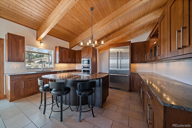 5197 Bear Mountain Dr, Evergreen, CO 80439 - kitchen featuring built in appliances, backsplash, a center island, wood ceiling, and vaulted ceiling with beams