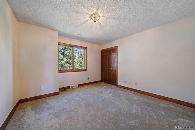 5197 Bear Mountain Dr, Evergreen, CO 80439 - unfurnished bedroom featuring a textured ceiling, carpet floors, baseboards, and visible vents