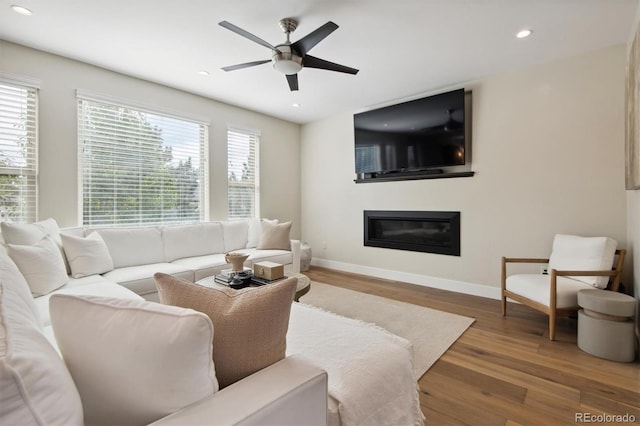 living room with plenty of natural light, hardwood / wood-style floors, and ceiling fan