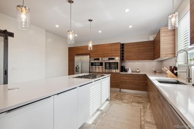 kitchen with sink, tasteful backsplash, decorative light fixtures, appliances with stainless steel finishes, and white cabinets