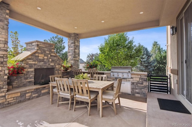 view of patio / terrace with a grill, exterior kitchen, and an outdoor stone fireplace