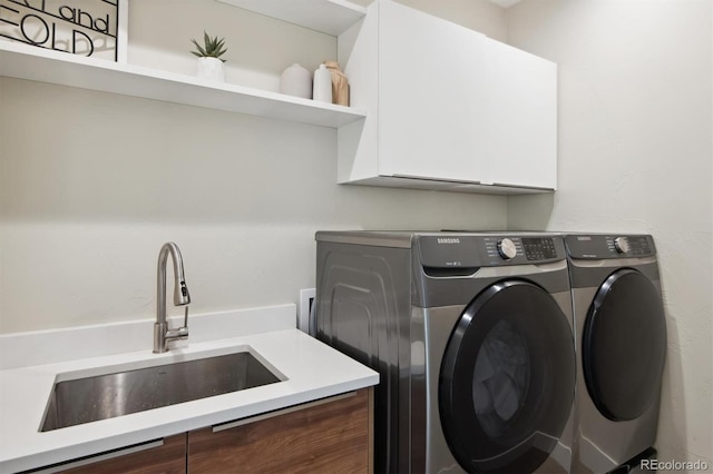 laundry room with separate washer and dryer, sink, and cabinets