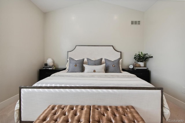 bedroom featuring light colored carpet and vaulted ceiling