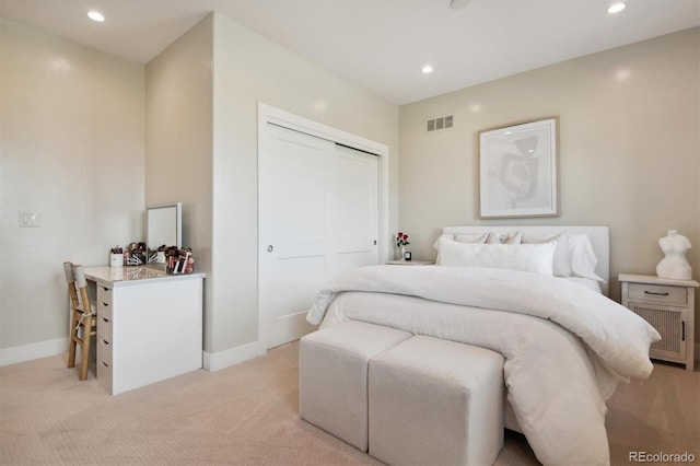 bedroom featuring light colored carpet and a closet