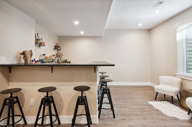 bar featuring light hardwood / wood-style floors