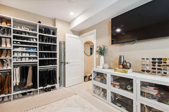 walk in closet with light carpet