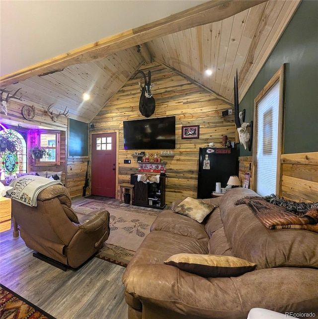 living area with vaulted ceiling with beams, wooden ceiling, wood walls, and wood finished floors