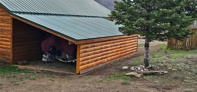 view of side of home with metal roof and log veneer siding