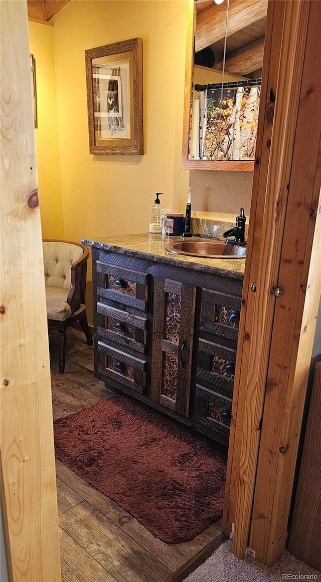 bar with wood finished floors, a sink, and wet bar