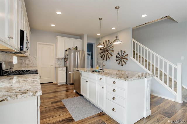 11038 Unity Ln, Commerce City, CO 80022 - kitchen with appliances with stainless steel finishes, decorative backsplash, dark wood-style floors, recessed lighting, and white cabinetry
